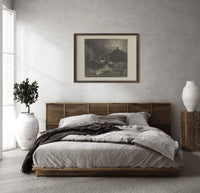 Centaurs shooting arrows at damned souls print in a dark wood frame above a rattan bed on a plaster wall