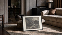 Centaurs shooting arrows at damned souls print in a slim black frame leaning on a travertine coffee table
