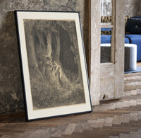Robed man in dark forest print in a black frame leaning beside a vintage door on parquet