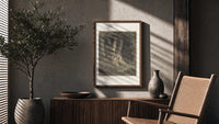 Robed man in dark forest poster framed above a fluted sideboard beside an olive tree