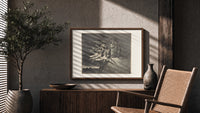 winged demons and two robed figures print in a wood frame above a fluted sideboard beside an olive tree