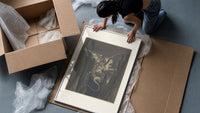 Winged monster carrying two figures framed print being unpacked from protective bubble wrap and a box