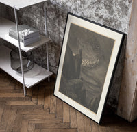 Souls swirling in whirlwind before figures poster in a black frame leaning beside a shelf in a raw-plaster loft