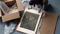 Souls swirling in whirlwind before figures framed print being unpacked from protective bubble wrap and a box