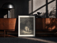 Black-framed Glowing woman and robed figure print on a moody console with designer coffee-table books