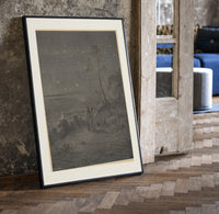 Two robed figures under starry sky print in a black frame leaning beside a vintage door on parquet