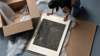 Demons on cliff, two robed travelers framed print being unpacked from protective bubble wrap and a box