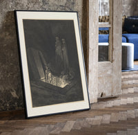 Figure rising from tomb in hell print in a black frame leaning beside a vintage door on parquet