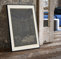 Two figures overlooking pit of souls print in a black frame leaning beside a vintage door on parquet