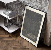Two figures overlooking pit of souls poster in a black frame leaning beside a shelf in a raw-plaster loft