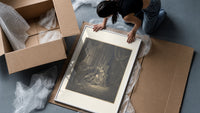 Lovers embracing on ornate throne framed print being unpacked from protective bubble wrap and a box