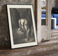 Giant crouching over two small figures print in a black frame leaning beside a vintage door on parquet