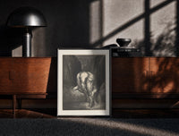 Black-framed Giant crouching over two small figures print on a moody console with designer coffee-table books