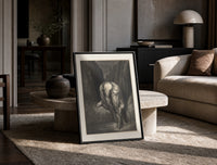 Giant crouching over two small figures print in a black frame leaning on a travertine table in a sunlit lounge