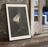 Two robed figures in rocky gorge print in a black frame leaning beside a vintage door on parquet