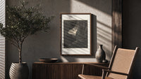 Two robed figures in rocky gorge poster framed above a fluted sideboard beside an olive tree