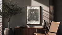 Winged demons flying above two robed figures poster framed above a fluted sideboard beside an olive tree