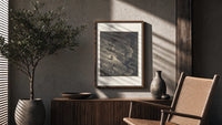 Two figures facing a winged monster poster framed above a fluted sideboard beside an olive tree
