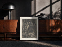 Black-framed Harpies in dark forest print on a moody console with designer coffee-table books