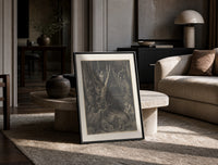 Harpies in dark forest print in a black frame leaning on a travertine table in a sunlit lounge