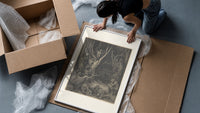 Harpies in dark forest framed print being unpacked from protective bubble wrap and a box