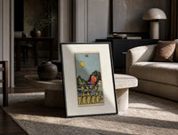 Figure walking away from eight cups print in a black frame leaning on a travertine table in a sunlit lounge