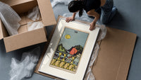 Figure walking away from eight cups framed print being unpacked from protective bubble wrap and a box