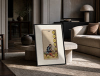 Craftsman carving pentacle coins print in a black frame leaning on a travertine table in a sunlit lounge