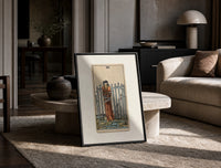 Blindfolded bound woman among swords print in a black frame leaning on a travertine table in a sunlit lounge