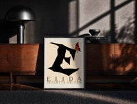Black-framed Butterfly on giant letter E print on a moody console with designer coffee-table books