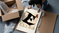 Butterfly on giant letter E framed print being unpacked from protective bubble wrap and a box