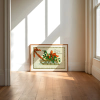 Christmas sled with holly and ribbon print in an oak frame on a sunlit wood floor beneath tall window light
