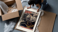 Woman on bicycle with tennis racket framed print being unpacked from protective bubble wrap and a box