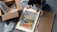 Sailboats on alpine lake bay framed print being unpacked from protective bubble wrap and a box
