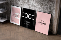 Chanel Wall Art Set set of three black-framed prints leaning against a raw-plaster wall