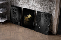 Black & Gold Playing Card set of three black-framed prints leaning against a raw-plaster wall