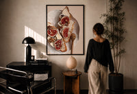 Figs, Cheese and Walnuts print in a black frame on a sunlit plaster wall, a woman looking on beside a mushroom lamp