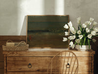 Figures on a beach by sea print in an oak frame on a farmhouse dresser beside white tulips