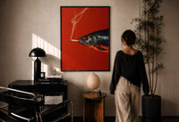 Fish Smoking a Cigarette print in a black frame on a sunlit plaster wall, a person looking on beside a mushroom lamp