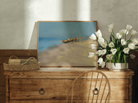 Fishermen with boat on beach print in an oak frame on a farmhouse dresser beside white tulips