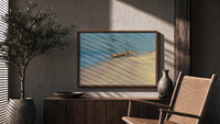 Fishermen with boat on beach print in a wood frame above a fluted sideboard beside an olive tree