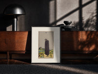 Black-framed Cloaked figure among spilled cups print on a moody console with designer coffee-table books