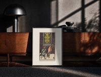 Black-framed Two beggars passing lit stained-glass window print on a moody console with designer coffee-table books