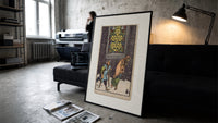 Two beggars passing lit stained-glass window print in a slim black frame leaning on a dark sofa in a concrete print studio