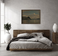 Fjord landscape with mountains and water print in a dark wood frame above a rattan bed on a plaster wall