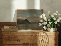 Fjord landscape with mountains and water print in an oak frame on a farmhouse dresser beside white tulips