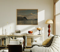 Coastal fjord landscape with headland print in an oak frame above a mid-century book console with a vintage radio