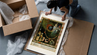 Oriental woman with peacock feather framed print being unpacked from protective bubble wrap and a box