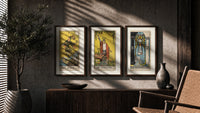 Three 1909 tarot cards triptych in three walnut frames above a sideboard in a warm room