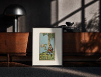Black-framed Seated man under tree with cups print on a moody console with designer coffee-table books